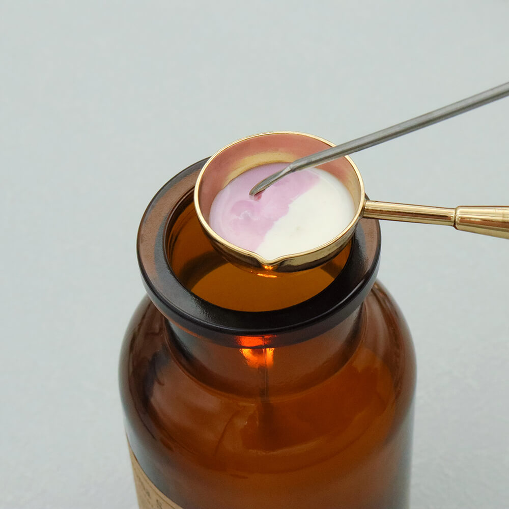 Stirring melted wax with a stirring stick